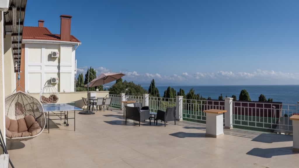 Терраса с креслами для отдыха и видом на море в отеле  VILLA MIRA  в Алуште, Крым